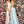 Clarisse 8105 is a long a-line prom dress with a low scoop neckline, open lace up back, side pockets, and a cross over high slit skirt.